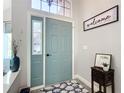 Inviting entryway with a teal door and a welcoming sign at 8476 Sw 108Th Place Rd, Ocala, FL 34481