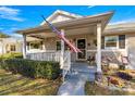 Home exterior featuring a porch, landscaping, and American flag at 8677 Sw 95Th Ln # F, Ocala, FL 34481