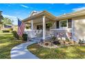 Charming front porch with rocking chairs and American flag at 8677 Sw 95Th Ln # F, Ocala, FL 34481