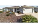 House exterior featuring a two-car garage and walkway at 10445 Sw 89Th Pl, Ocala, FL 34481