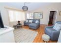 Spacious living room with a sectional sofa, hardwood floors, and large windows at 10602 Se 179Th Ln, Summerfield, FL 34491
