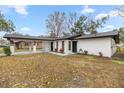 White single story house with a carport and landscaping at 11 Bahia Court Loop, Ocala, FL 34472