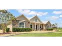Stone and siding exterior of a single-story home showcasing a welcoming front porch and manicured landscaping at 12000 S Highway 475, Ocala, FL 34480