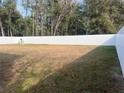 Large backyard with a white vinyl fence and open grassy area at 14351 Se 34Th Ct, Summerfield, FL 34491