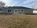 Rear view of a one-story house with sliding glass doors and a grassy yard at 14351 Se 34Th Ct, Summerfield, FL 34491