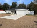 Newly built home with gray siding, white garage door and a fenced yard at 14351 Se 34Th Ct, Summerfield, FL 34491