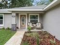 Inviting front porch with two wicker chairs, enhancing curb appeal at 205 Brevard Ave, Lady Lake, FL 32159