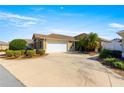 Single story home with a two-car garage and mature landscaping at 2997 Teasdale Ter, The Villages, FL 32163