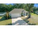 Single-story house with driveway and green lawn, viewed from above at 302 Brookstone Ln, Fruitland Park, FL 34731