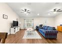 Bright living room featuring hardwood floors, a comfy sofa, and large windows at 3707 Se 24Th St, Ocala, FL 34471