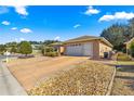 Front view of a single-story house with a driveway and landscaping at 8125 Sw 81St Loop, Ocala, FL 34476