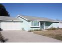 Front view of a light blue house with a gray roof and attached garage at 8667 Sw 108Th Pl, Ocala, FL 34481