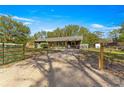 House with a gravel driveway and a green gate at 10425 Se 159Th Lane, Summerfield, FL 34491