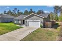 Traditional home featuring a 1-car garage, concrete driveway, and a manicured lawn at 13787 Sw 43Rd Cir, Ocala, FL 34473