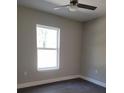 Bright bedroom with large window, ceiling fan, and dark gray flooring at 14259 Se 33Rd Ter, Summerfield, FL 34491