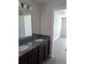 Bathroom with a double vanity and granite countertop with access to the bedroom at 2792 Sw 161St Loop, Ocala, FL 34473