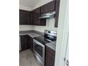 This kitchen features stainless steel appliances and dark cabinets at 2792 Sw 161St Loop, Ocala, FL 34473