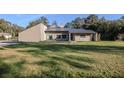 Tan house with metal roof and a large backyard at 3261 Se 41St Pl, Ocala, FL 34480