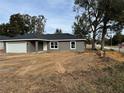 Newly built home, gray exterior, white garage door, landscaped yard at 3957 Se 137Th Ln, Summerfield, FL 34491