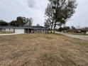 Inviting single-story home with a gray exterior, a two-car garage, and a spacious front yard at 3957 Se 137Th Ln, Summerfield, FL 34491