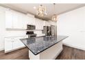 Modern kitchen with stainless steel appliances, granite countertops, and white cabinets at 4721 Se 25Th Loop, Ocala, FL 34480