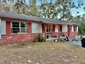 Ranch style home with red accents and a covered porch at 5625 Sw 181St Ct, Dunnellon, FL 34432