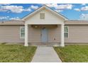 Well-lit front door, cream-colored exterior with green grass at 5885 Sw 169Th Ct, Ocala, FL 34481