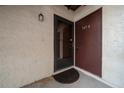 Condo unit's front door with storm door and mat at 749 Midway Dr # A, Ocala, FL 34472