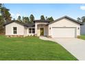 Newly built single-story house with a two-car garage and grassy yard at 7747 Sw 146Th Lane Rd, Ocala, FL 34473