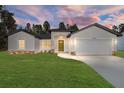 New single-story home with attached garage, and a well-manicured lawn at 7747 Sw 146Th Lane Rd, Ocala, FL 34473