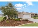 Tan house with white garage door and mature landscaping at 7838 Sw 85Th Cir, Ocala, FL 34481