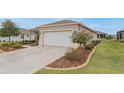 Tan house with white garage door and landscaping at 7838 Sw 85Th Cir, Ocala, FL 34481