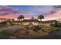 Stately home featuring mature landscaping, a circular driveway, and inviting arched entryway at 8250 Nw 136Th Avenue Rd, Ocala, FL 34482