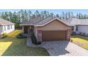 One-story house with brown garage door and a landscaped yard at 9119 Sw 70Th Loop, Ocala, FL 34481