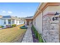 House exterior showcasing walkway, landscaping, and stone accents at 9119 Sw 70Th Loop, Ocala, FL 34481