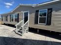 Tan mobile home with black shutters and a grey front porch at 9160 Sw 31St Avenue Rd, Ocala, FL 34476