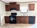 Modern kitchen with dark wood cabinets and black appliances at 9160 Sw 31St Avenue Rd, Ocala, FL 34476