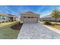 Two-car garage with paver driveway and landscaping at 10277 Sw 96Th Loop, Ocala, FL 34481