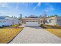 Inviting home exterior featuring a beautiful brick driveway and a well-kept lawn, offering a warm and welcoming curb appeal at 10306 Sw 99Th Ln, Ocala, FL 34481