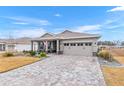 One-story house featuring a paver driveway and manicured lawn at 10339 Sw 96Th Ln, Ocala, FL 34481