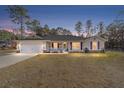 House exterior at dusk showcasing front porch and landscaping at 13700 Sw 71St Ln, Ocala, FL 34481