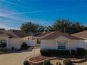 Tan one-story house with brown roof and landscaped yard at 17074 Se 75Th Wickson Ct, The Villages, FL 32162