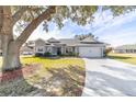 Gray house with white accents, two-car garage, and landscaped yard at 17470 Se 115Th Terrace Rd, Summerfield, FL 34491