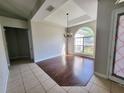 Bright dining area with elegant chandelier, hardwood accent, tray ceiling and large arched window at 1908 Sw 28Th St, Ocala, FL 34471