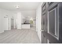 Open living room with gray carpeting and views into kitchen at 24130 Nw Banyan Ln, Dunnellon, FL 34431