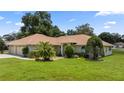 Tan house with a two-car garage and palm trees at 6558 Se 9Th Pl, Ocala, FL 34472