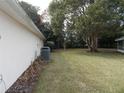 Side yard view showing a grassy area and mature trees at 7106 Sw 115Th Loop, Ocala, FL 34476