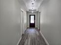 Hallway features wood floors and modern hanging light fixtures at 7799 Sw 132Nd Pl # 10, Ocala, FL 34473
