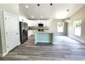 A bright kitchen is featured with white cabinets, a center island, stainless appliances, and modern lighting at 7799 Sw 132Nd Pl # 10, Ocala, FL 34473