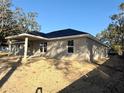 Side view of new construction home with covered patio and partially landscaped yard at 8724 Se 157Th Pl, Summerfield, FL 34491